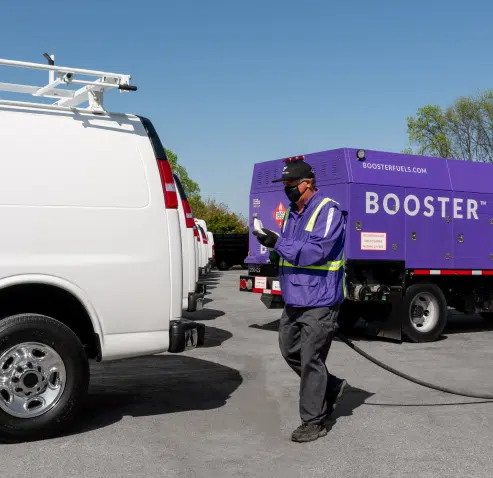man walking to fuel awhite van